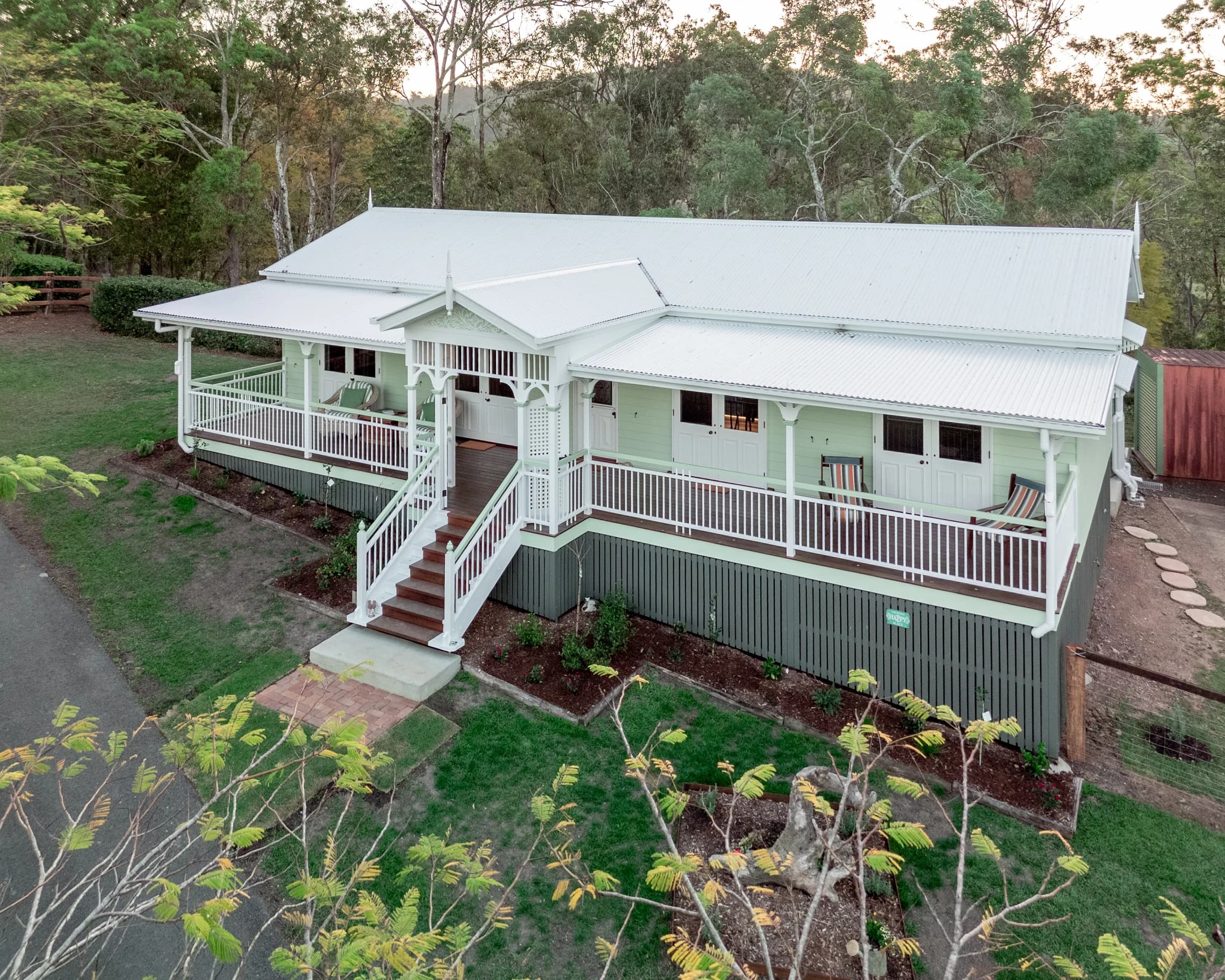 Aerial view of Kobble Cottage with its white roof and wraparound veranda.