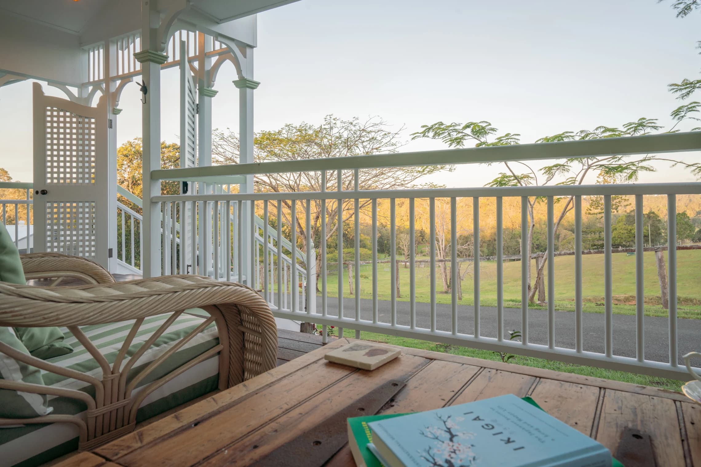 A book and wicker seating on the veranda overlooking the paddocks.
