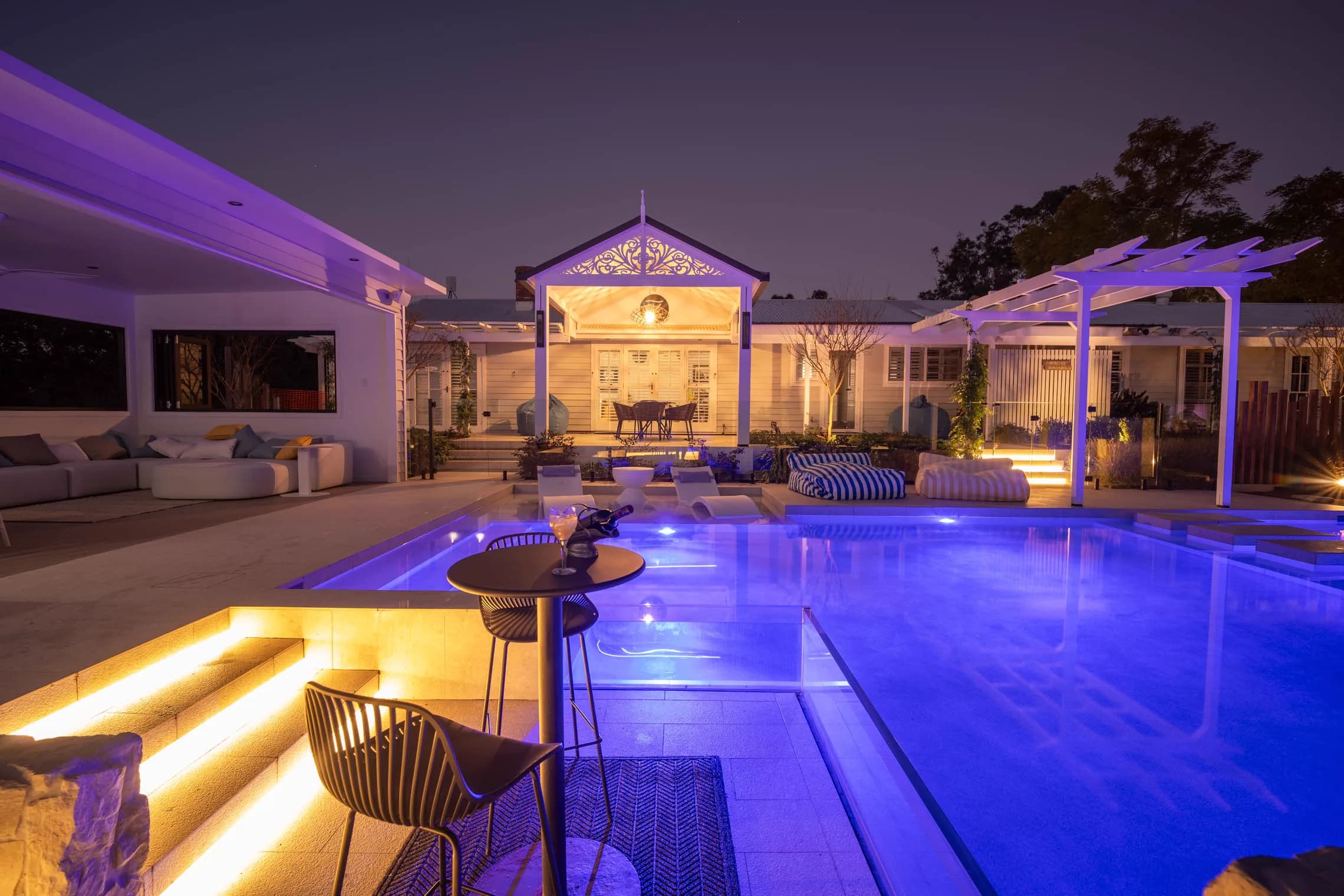 The homestead and its illuminated pool at night.