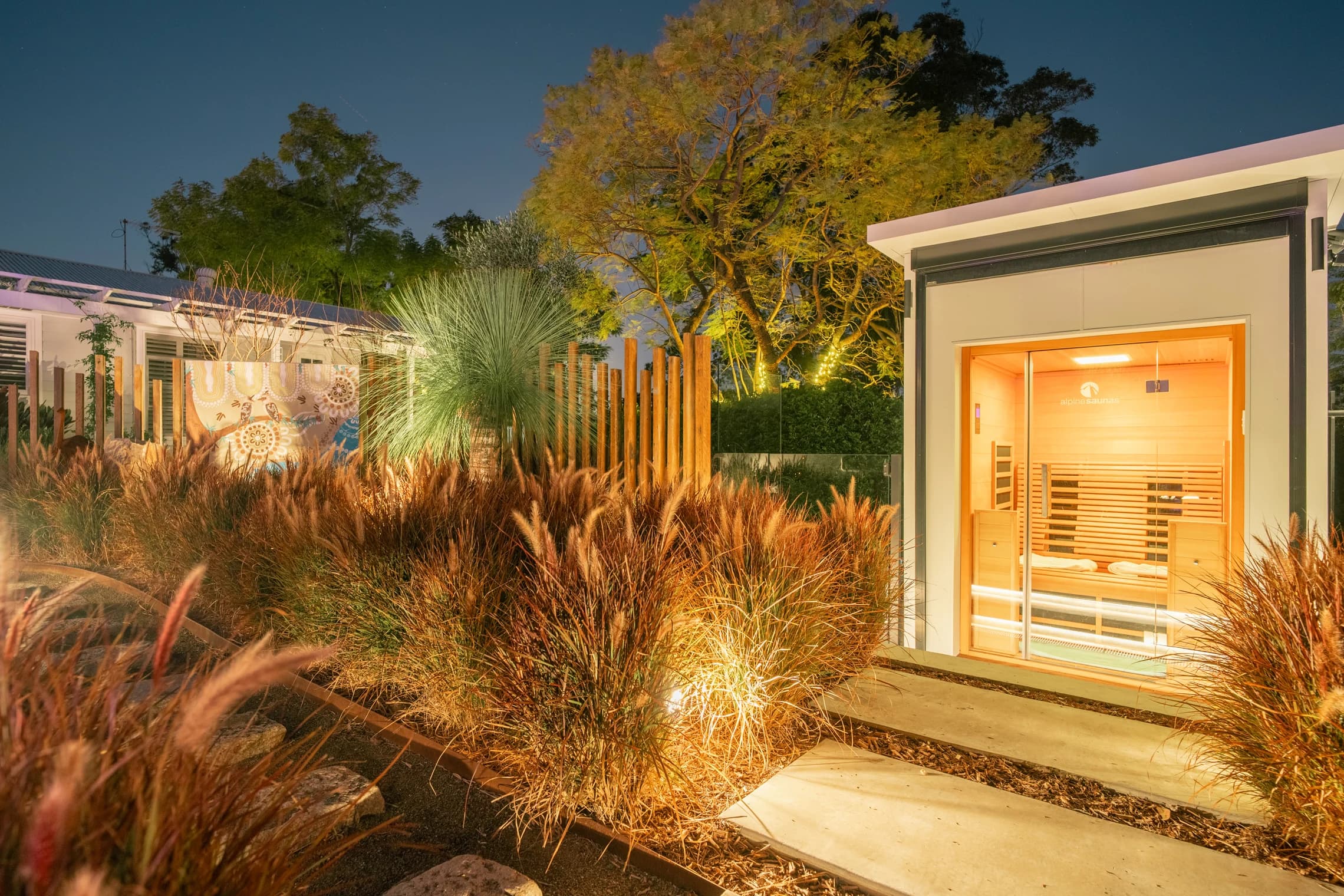 A lit path through the garden leads to the open sauna.