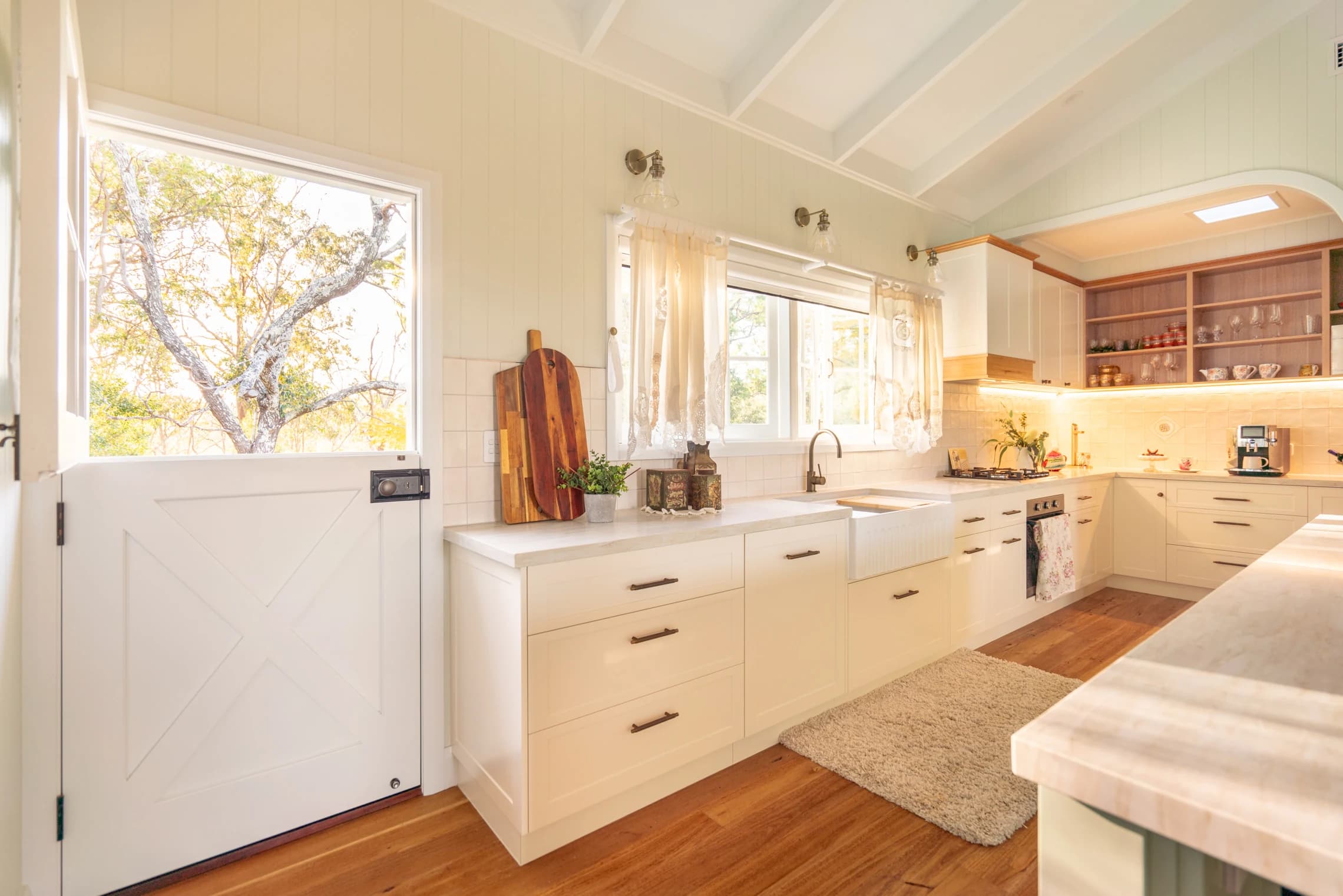 The farmhouse sink and open Dutch door looking onto trees.
