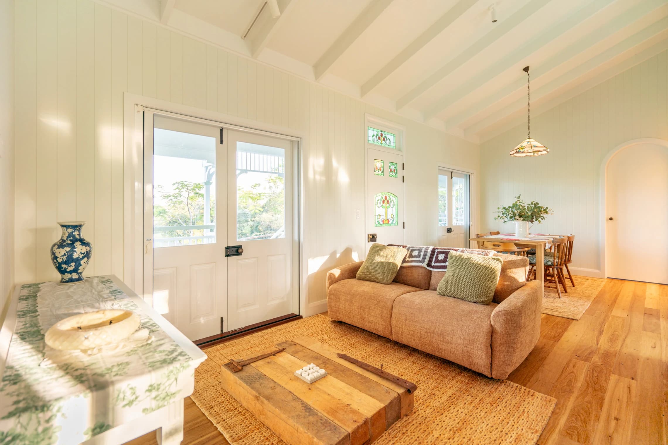 A tan sofa and timber coffee table beside French doors to the veranda.