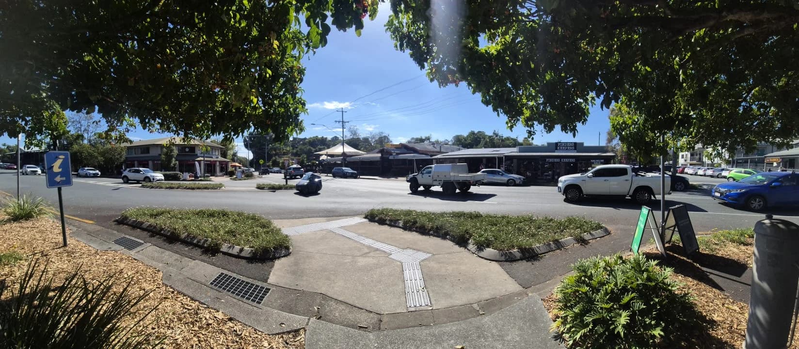 A panoramic view across Samford village street towards local shops.